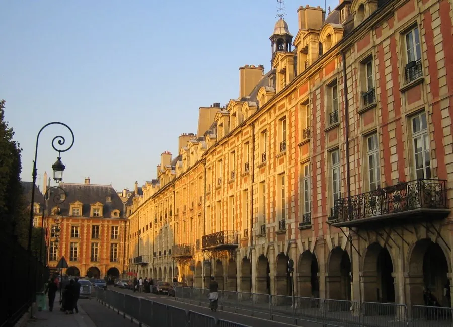 Façades de brique et arcades de la place des Vosges dans la lumière du soir